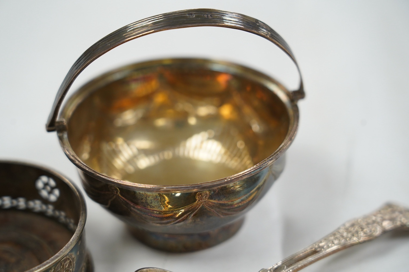 A George III silver small epergne basket, London, 1800, diameter 80mm, a large William IV silver caddy spoon and an Old Sheffield plate sauce bottle coaster. Condition - fair